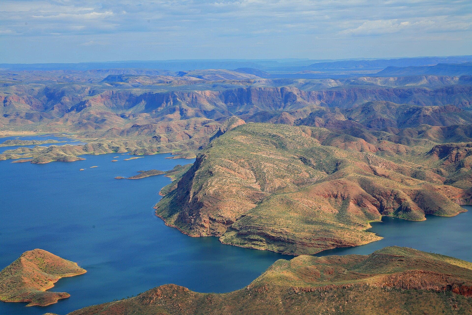 Wide blue waters of Lake Argyle with rocky Kimberley islands and a late-afternoon sky.