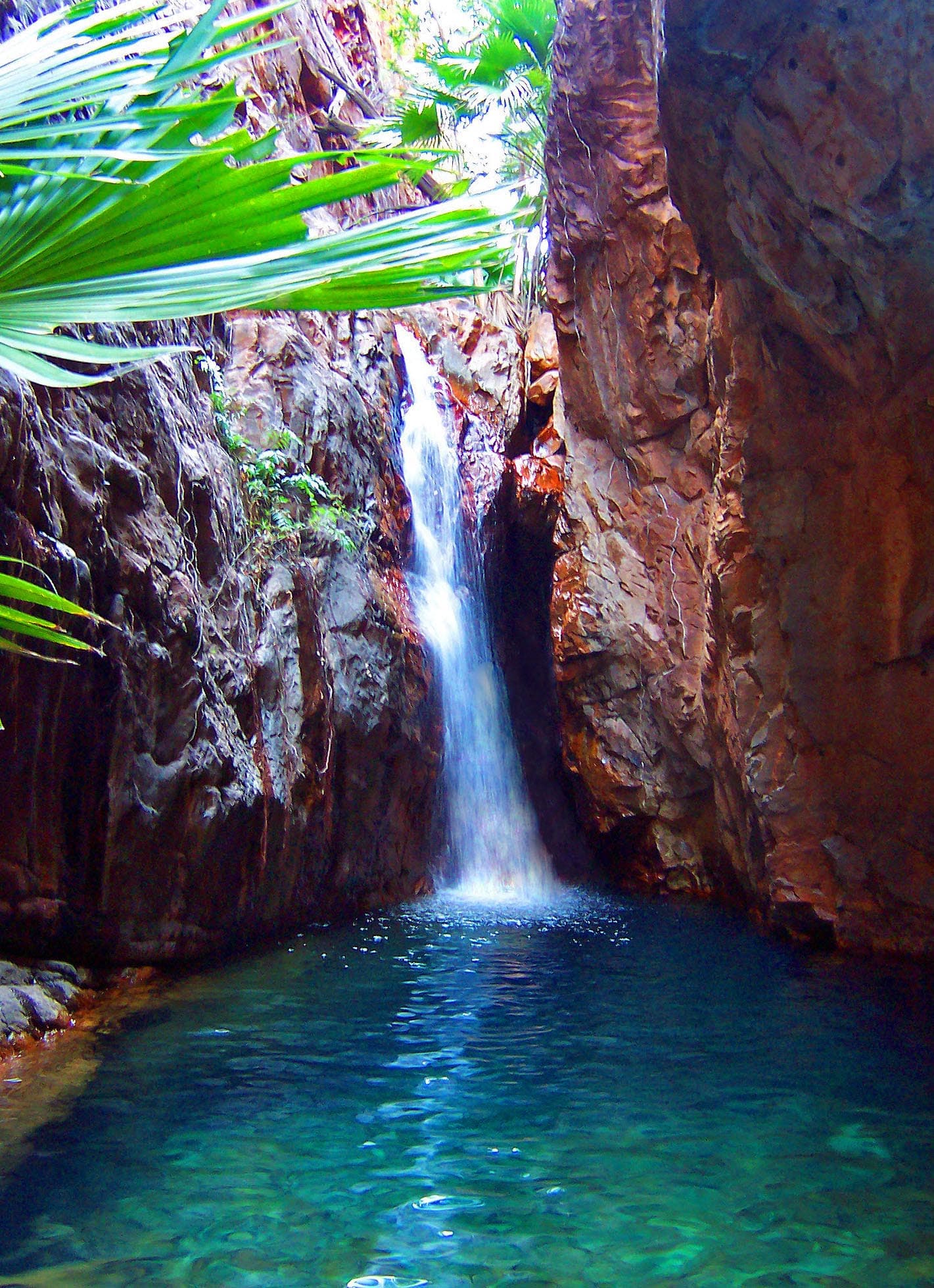 Water falling over dark rock into a shaded pool in El Questro Gorge, eastern Kimberley.