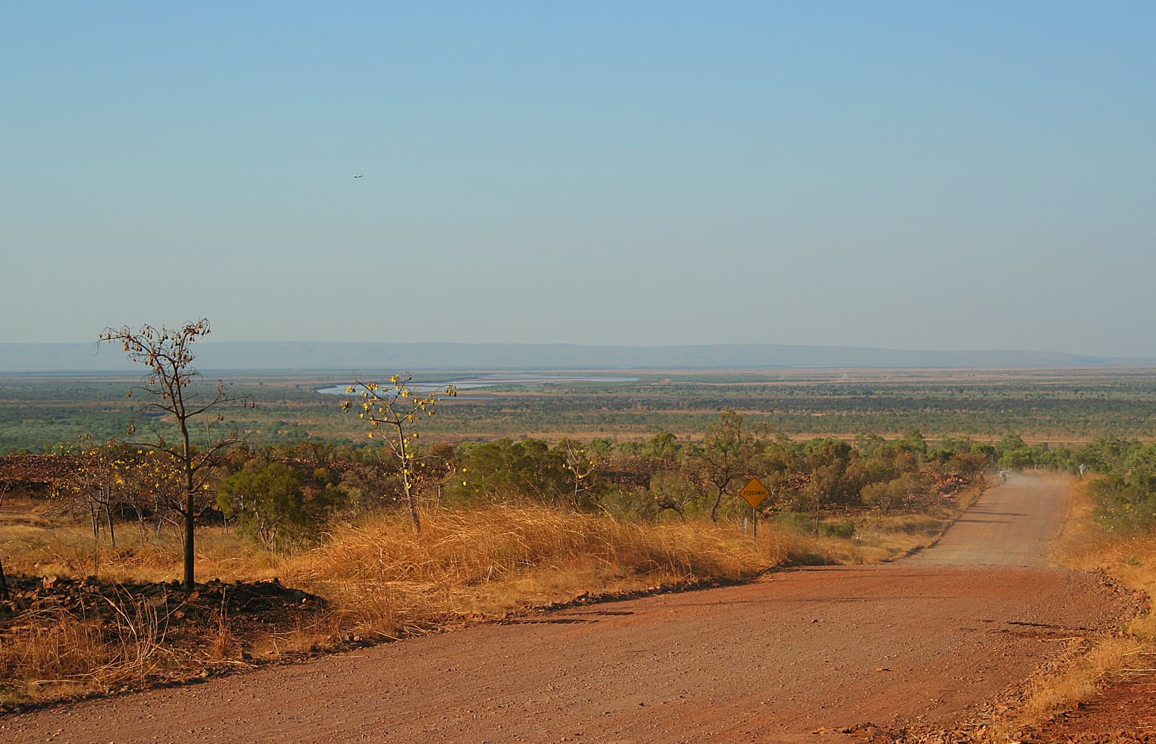 Red laterite outback road through dry savanna on the Gibb River Road, Kimberley.